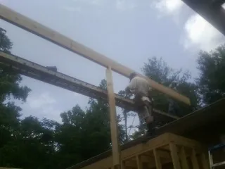 Carpenter setting a ridge beam over a new addition frame — Ice Dam Removal by Roofing Brothers in Warwick