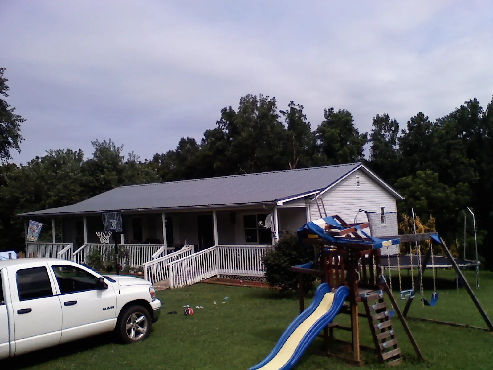 Dark metal roof on a country home with a full length front porch in Warwick